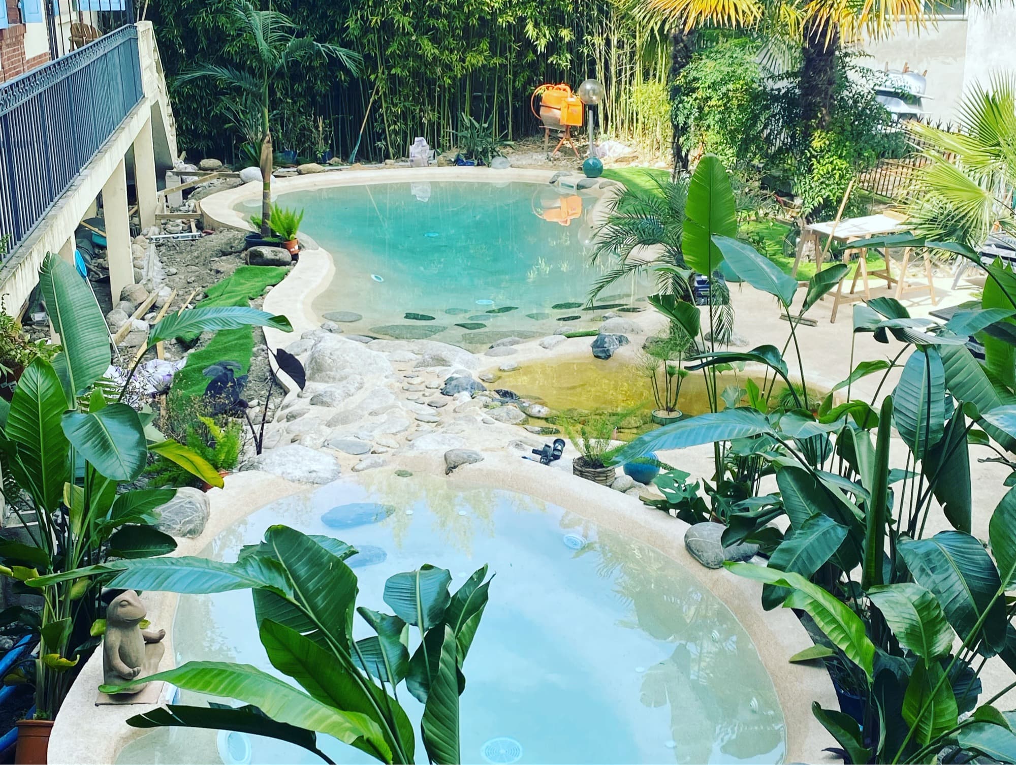Jardin exotique luxuriant avec bassins étagés et bananiers